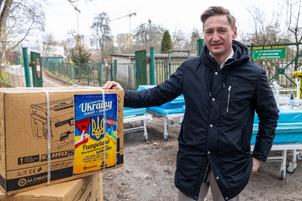 Marszałek Geblewicz kompletuje dary dla Ukrainy, w tle kartony z pomocą. 