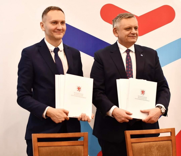 Rafał Rosiński i Piotr Jedliński trzymają umowy